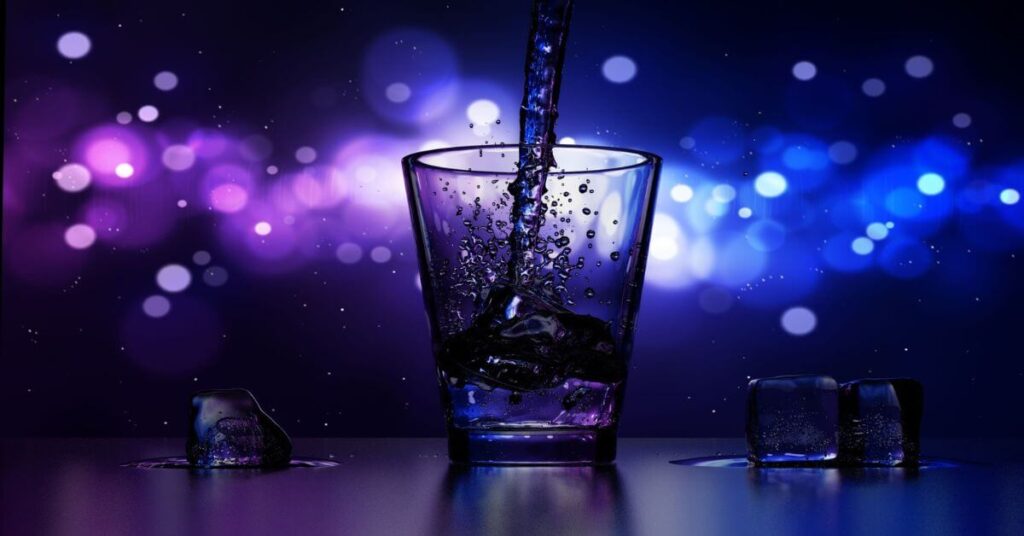Imagem de um copo com gelo, sendo enchido por um líquido que parece sair de uma garrafa. Imagem destacada do site louvare.com, referente ao post: O que a Bíblia diz sobre beber álcool?