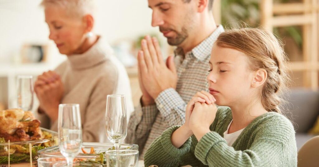 Imagem de uma família orando e agradecendo a Deus, antes de comerem. Imagem destacada do site louvare.com, referente ao post: Reflexão: Versículo 1 Tessalonicenses 5:18 – Gratidão e Reconhecimento